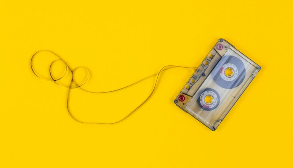 Unwound cassette tape on yellow background