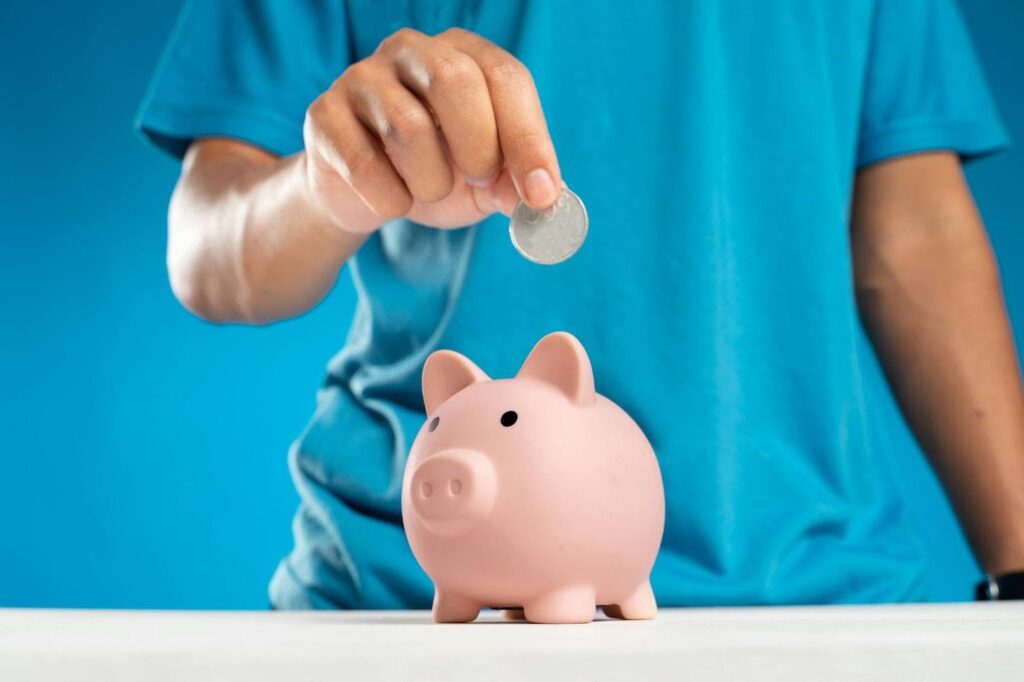 Man putting a quarter into a piggy bank